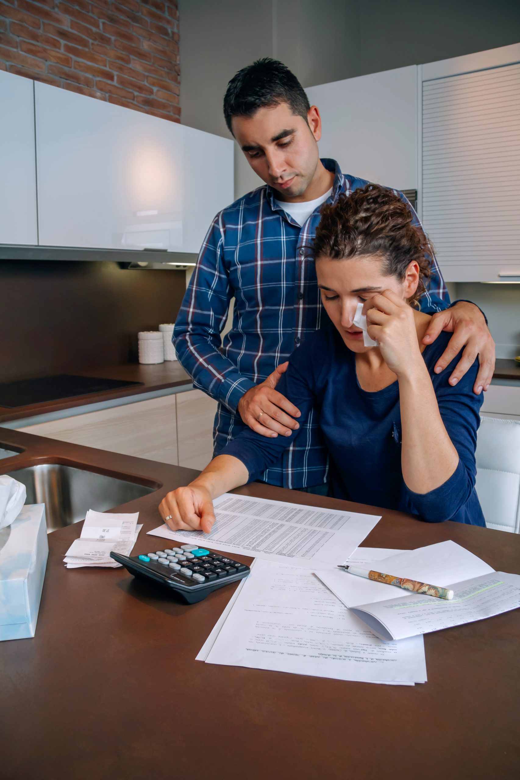 Desperate young woman with debts reviewing the bills